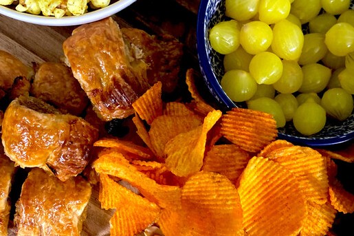 Borrelplank met kerrie popcorn, camembert uit de oven en mini saucijzenbroodjes