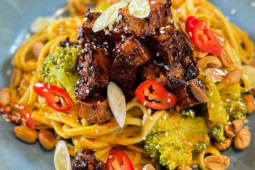 Rode curry met noedels, tofu en geroosterde pinda's