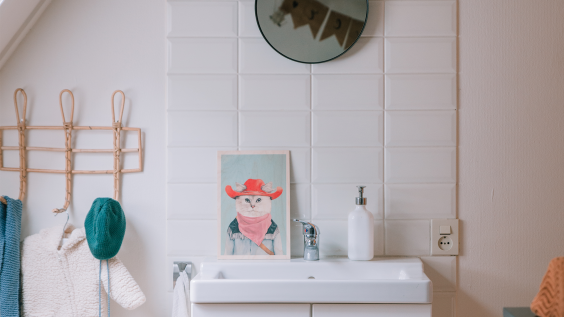 De badkamer van zoon Oliver is versierd met een schilderij en vlaggetjes - Fotografie: Sheena Schouwink