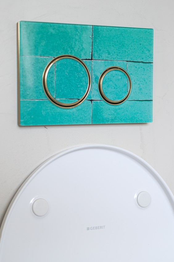 Witte badkamer met mozaïektegels op de vloer en een zeegroene wand achter het toilet | Foto Chiela van Meerwijk