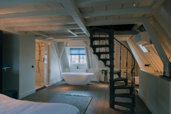 Hier is het toilet juist onopvallend en trekt de prachtige trap in de slaapkamer annex badkamer de alle aandacht naar zich toe | Foto Sheena Schouwink