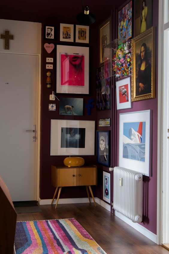 De hal is geschilderd in een gedurfde kleur en hangt vol schilderijen | Fotografie: Liesbeth Disbergen