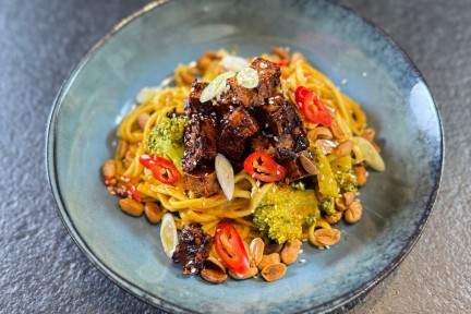 Rode curry met noedels, tofu en geroosterde pinda's