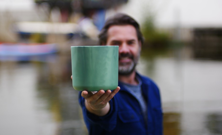 Marius laat hier een bloempot zien waarvoor ook plastic vezels zijn gebruikt opgevist uit het water | Foto: Plastic Whale
