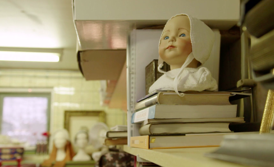 Kopje van een pop met klederdracht kap | Still uit de uitzending