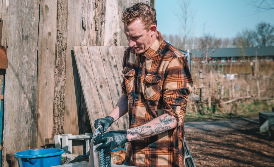Niels bereidt de vis bij zijn rokerij in Amsterdam | Foto: Sheena Schouwink