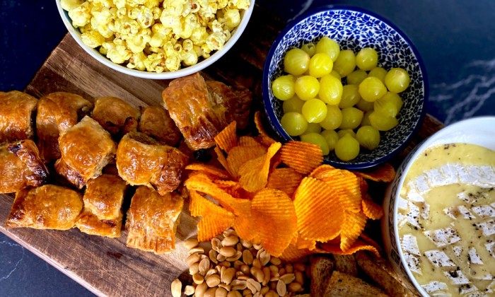 Borrelplank met kerrie popcorn, camembert uit de oven en mini saucijzenbroodjes