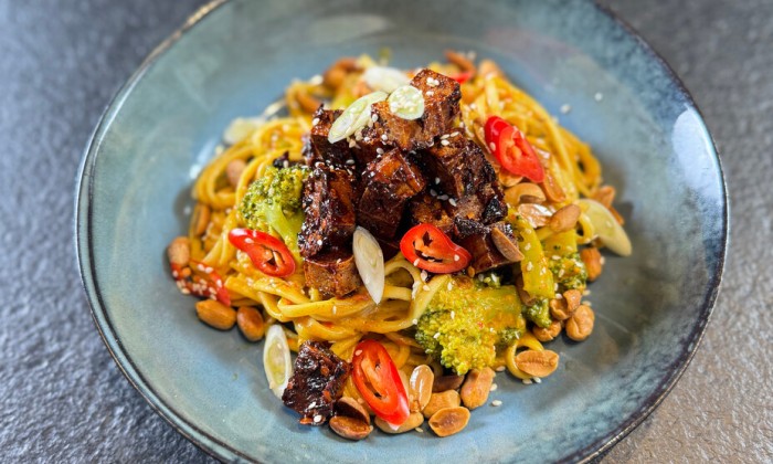 Rode curry met noedels, tofu en geroosterde pinda's