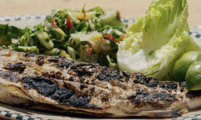Verse zeebaars van de barbecue en geserveerd met een frisse en pittige salade.